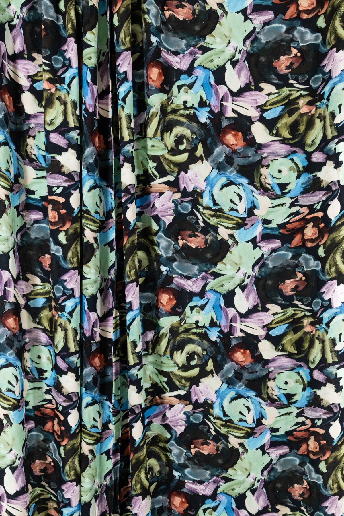 Vibrant floral print fabric with bold blue, green, purple, and black brushstroke flowers on dark background, ideal for apparel sewing.