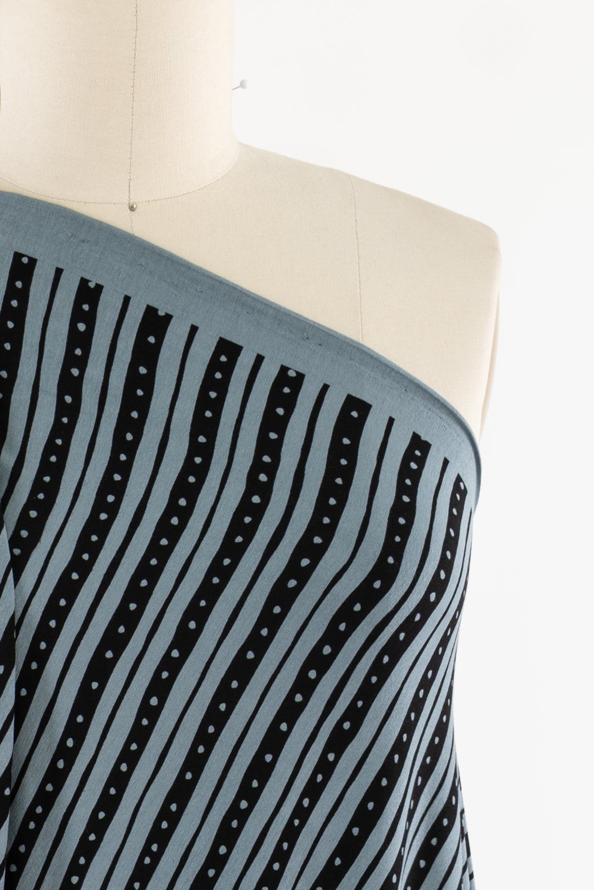 Blue and black striped fabric with white dots, displayed on a mannequin for apparel sewing projects.