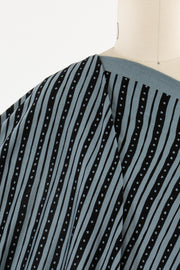 Blue and black striped fabric with white dots, draped on mannequin for apparel sewing