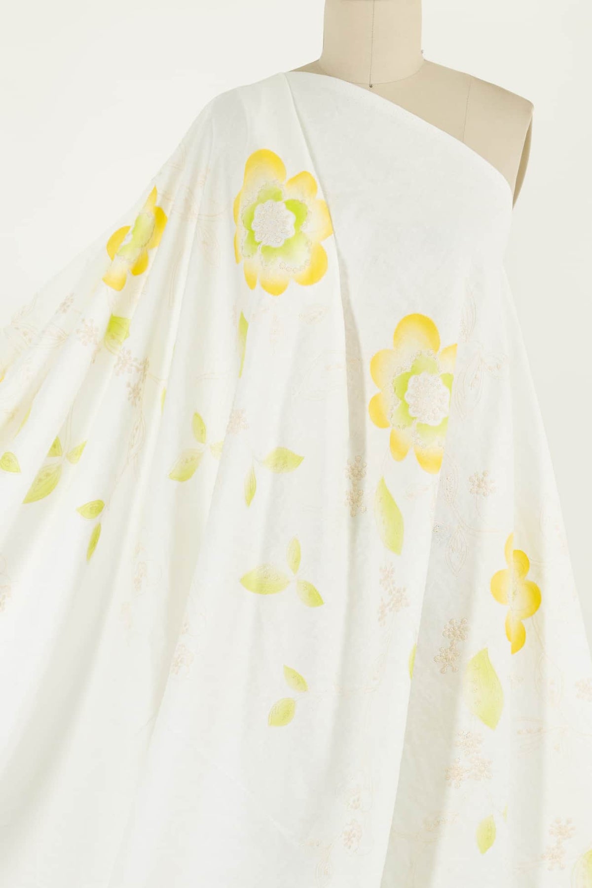 White fabric with yellow floral print, ideal for apparel sewing and quilting projects