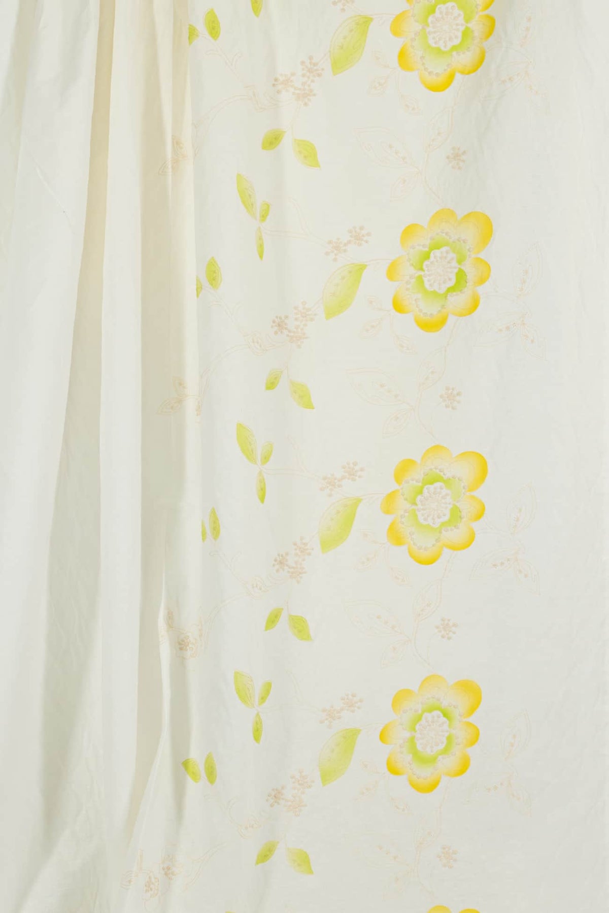 Cream fabric with yellow and green floral print, ideal for apparel and quilting projects