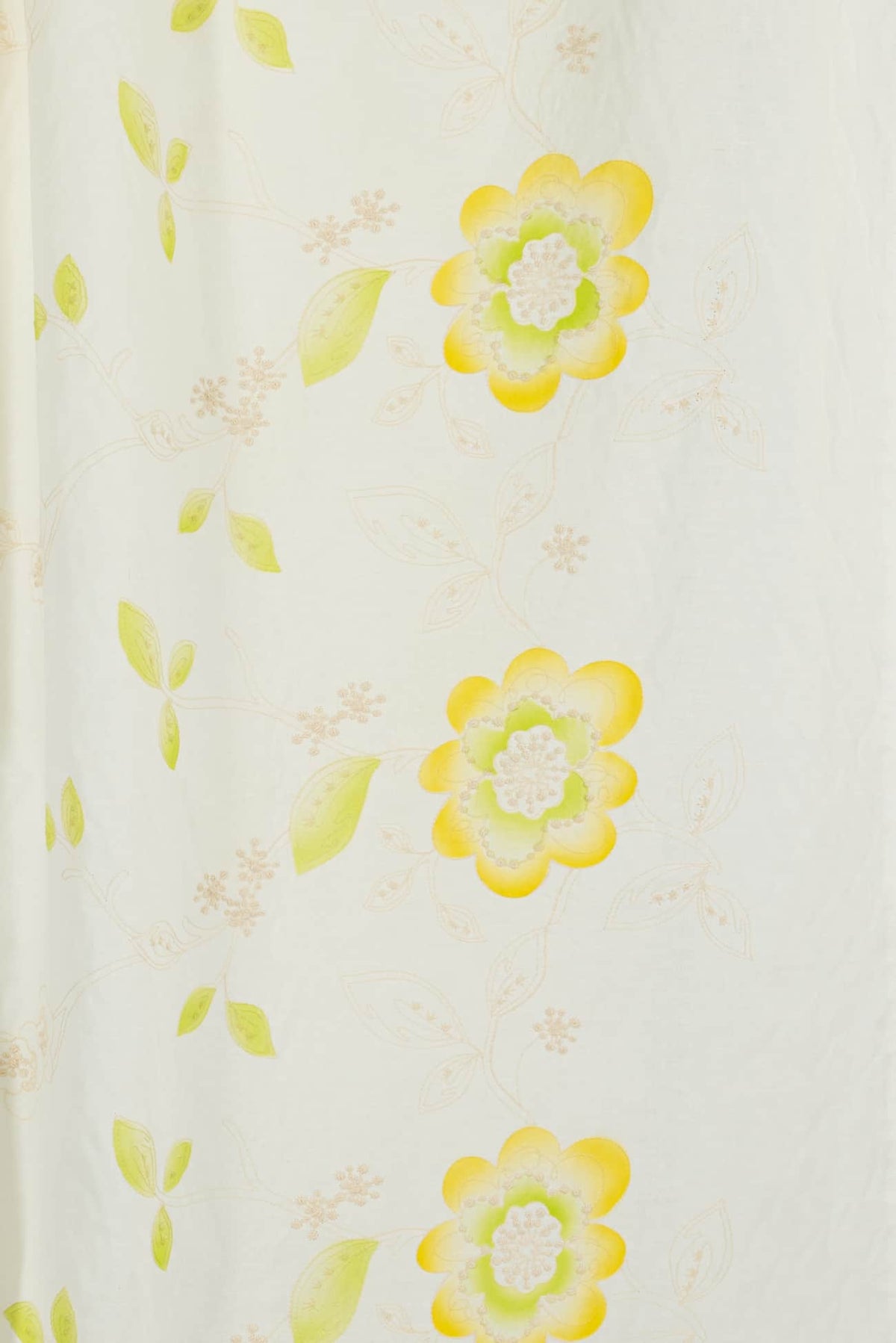Yellow and green floral print fabric for apparel sewing, featuring soft blooms and leaves on light background