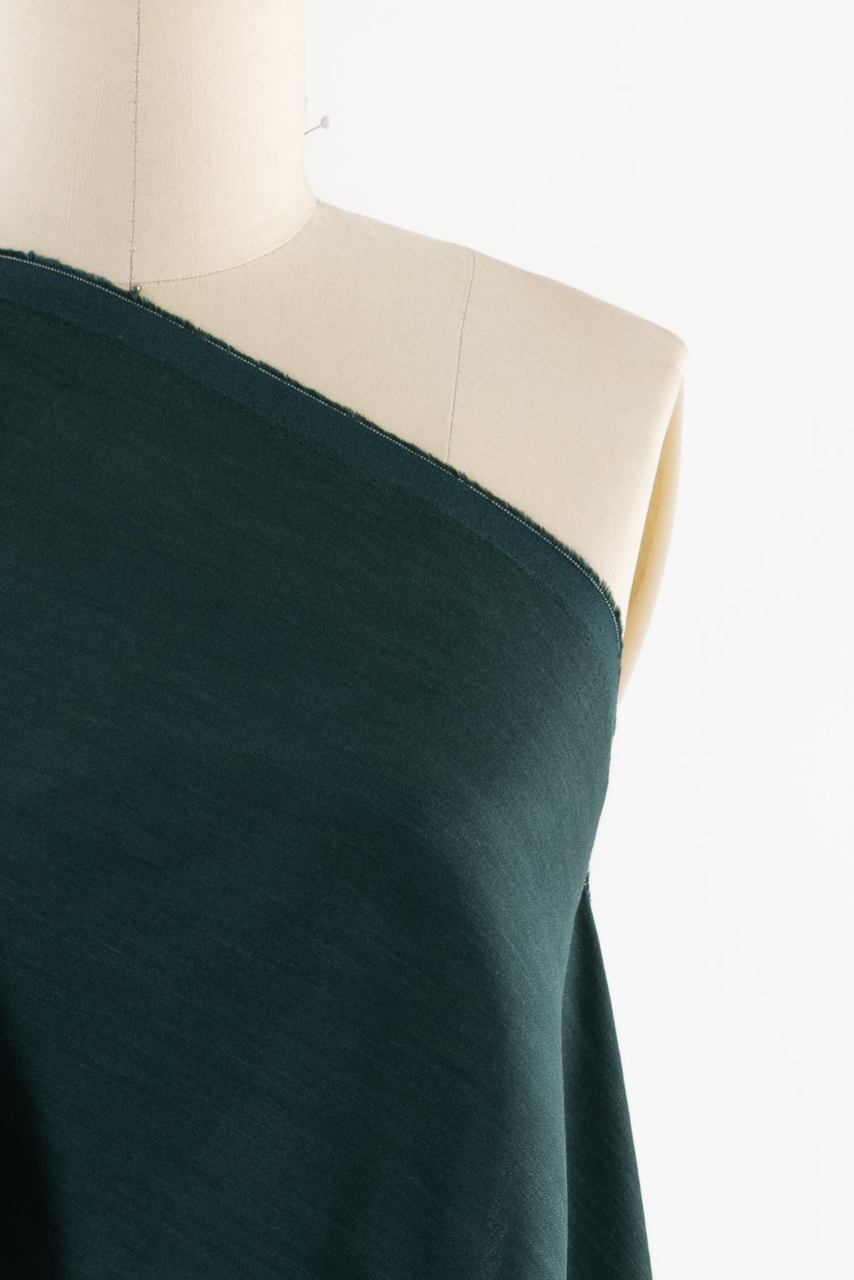 Dark green fabric draped on mannequin, ideal for apparel sewing and fashion projects