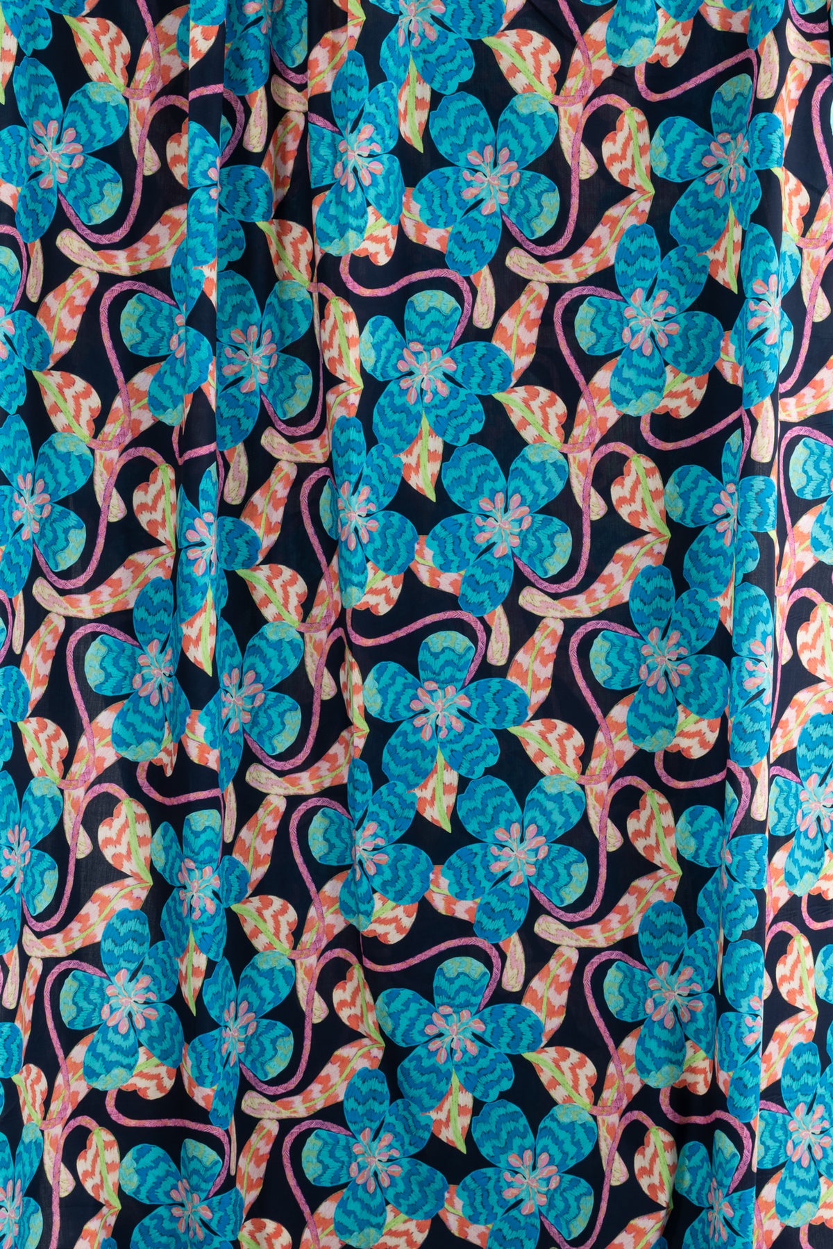 Vibrant blue floral print fabric with pink and orange accents on dark background, ideal for apparel sewing