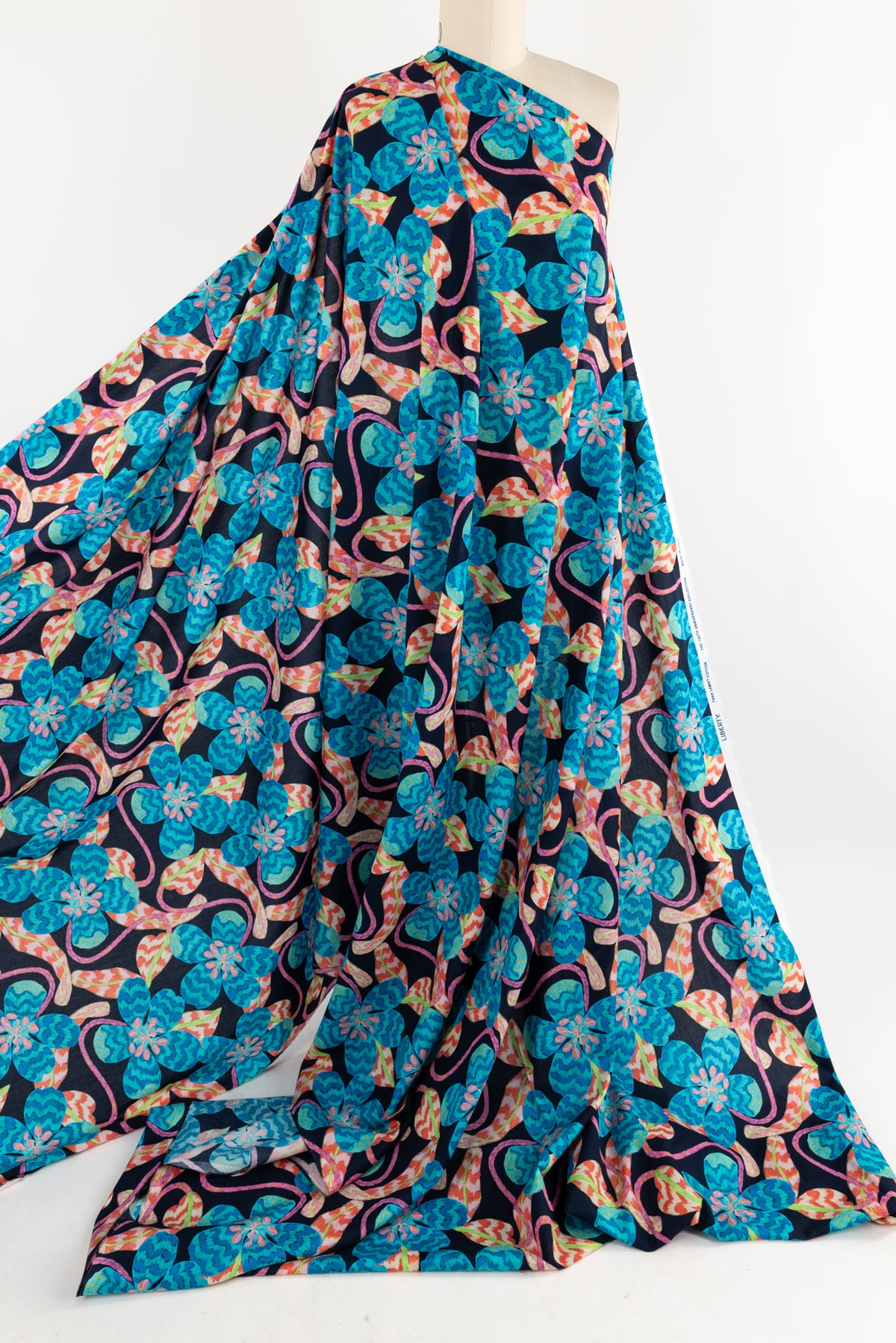 Vibrant floral print fabric with blue, pink, and orange blooms on black background, ideal for apparel sewing