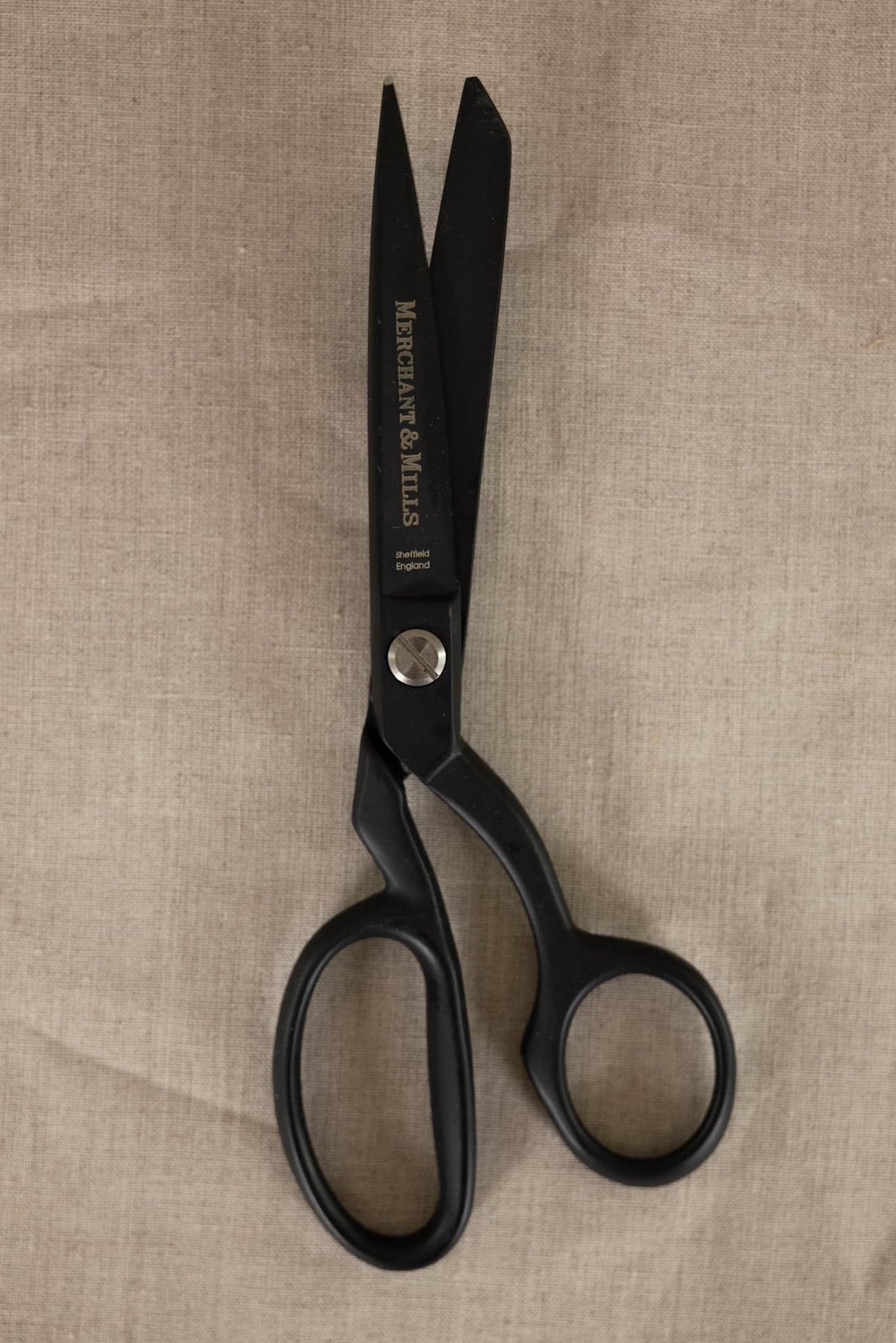 Merchant & Mills black fabric scissors on natural linen, ideal for sewing and cutting textiles
