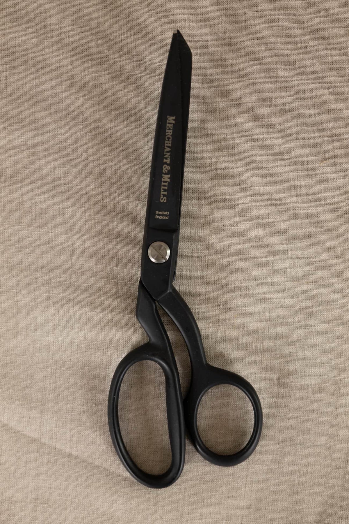 Black Merchant & Mills fabric scissors on natural linen fabric for sewing and crafting