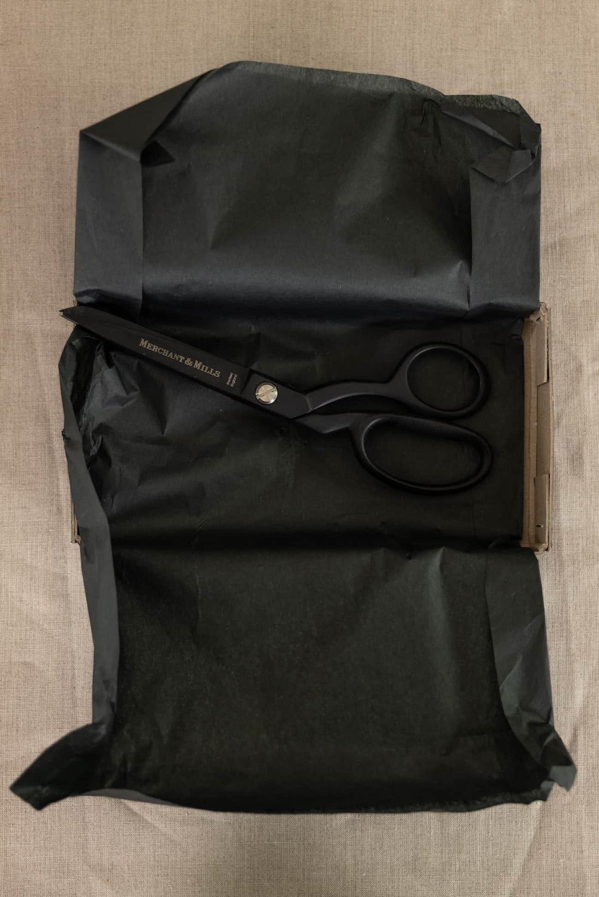Black Merchant & Mills fabric scissors on tissue paper, ideal for sewing and cutting textiles