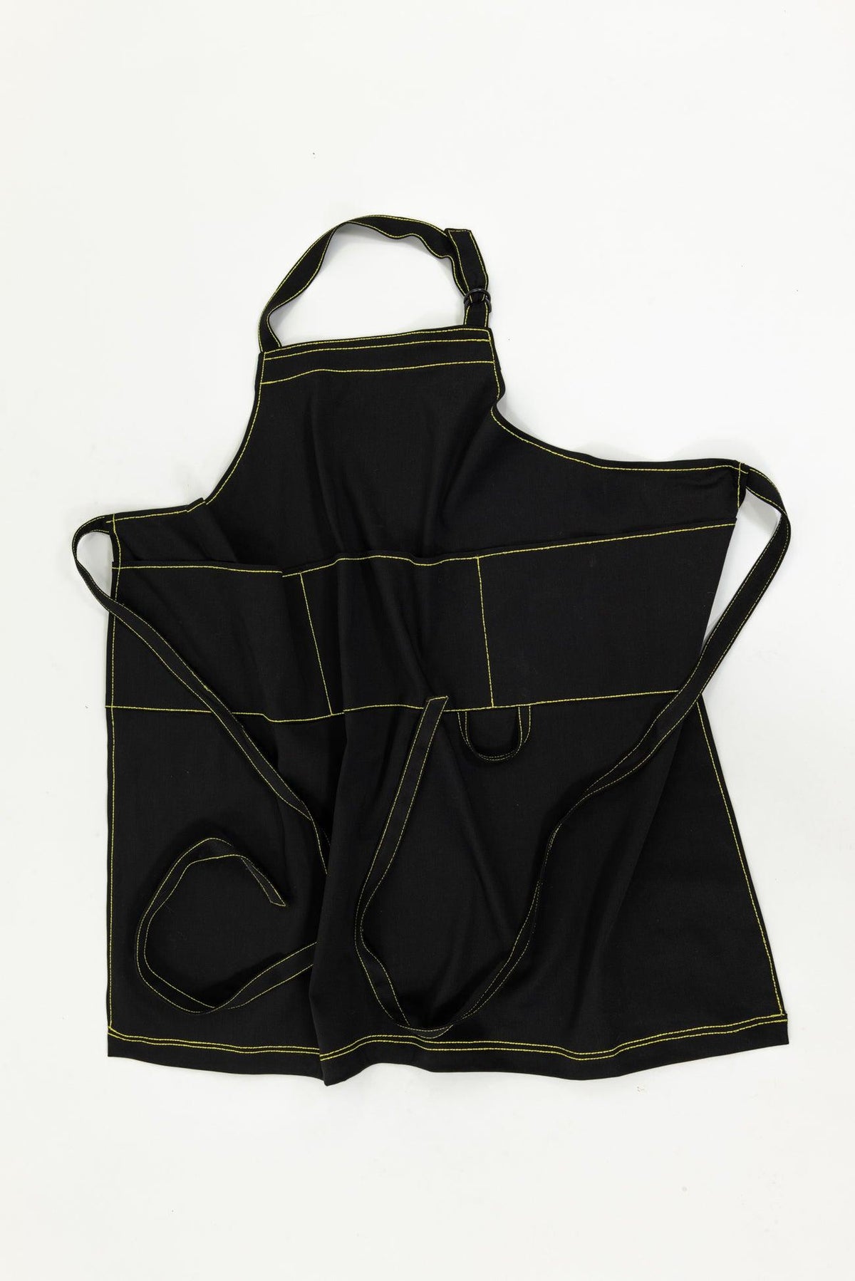 Black fabric apron with yellow contrast stitching, multiple pockets, and adjustable neck strap for sewing or crafting.
