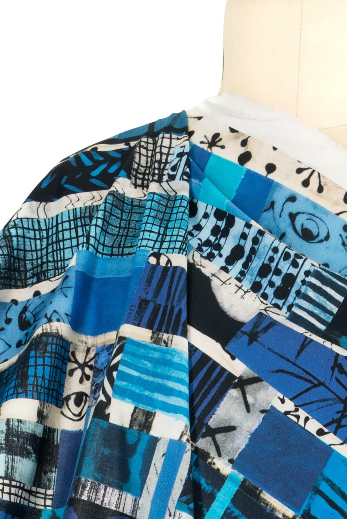 Blue abstract geometric print fabric draped on mannequin, ideal for apparel sewing projects