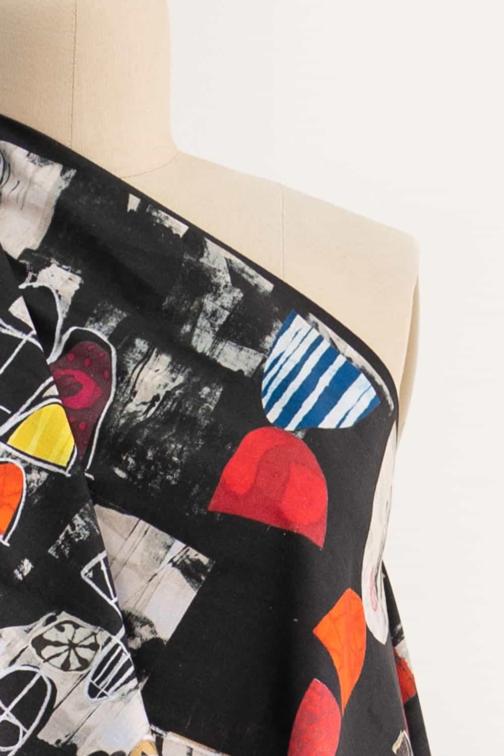 Abstract geometric print fabric in black, red, blue, and yellow on a mannequin — ideal for apparel sewing projects.