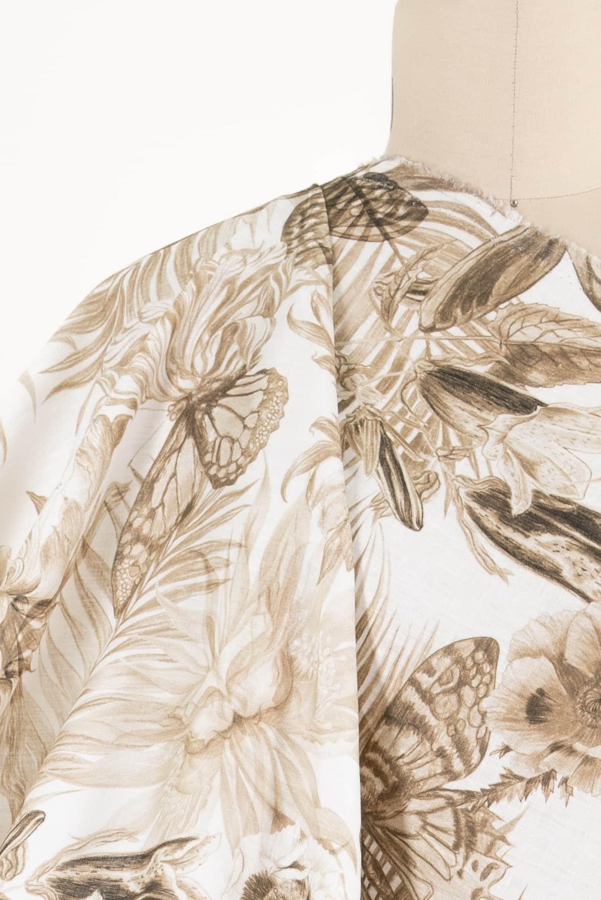 Floral and butterfly print fabric in brown tones, ideal for apparel sewing and fashion projects