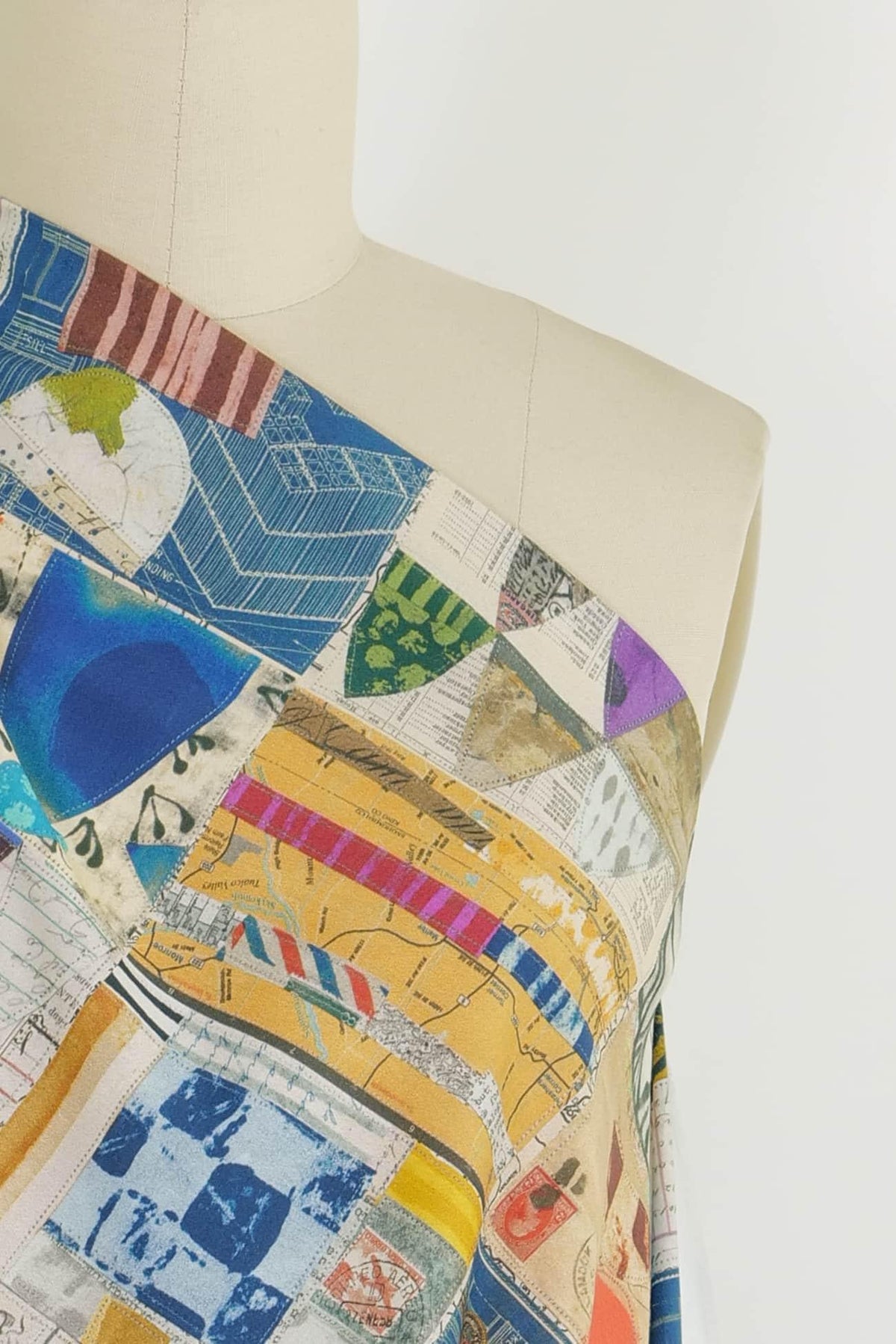 Colorful patchwork fabric with map and stamp prints, ideal for quilting and apparel sewing projects
