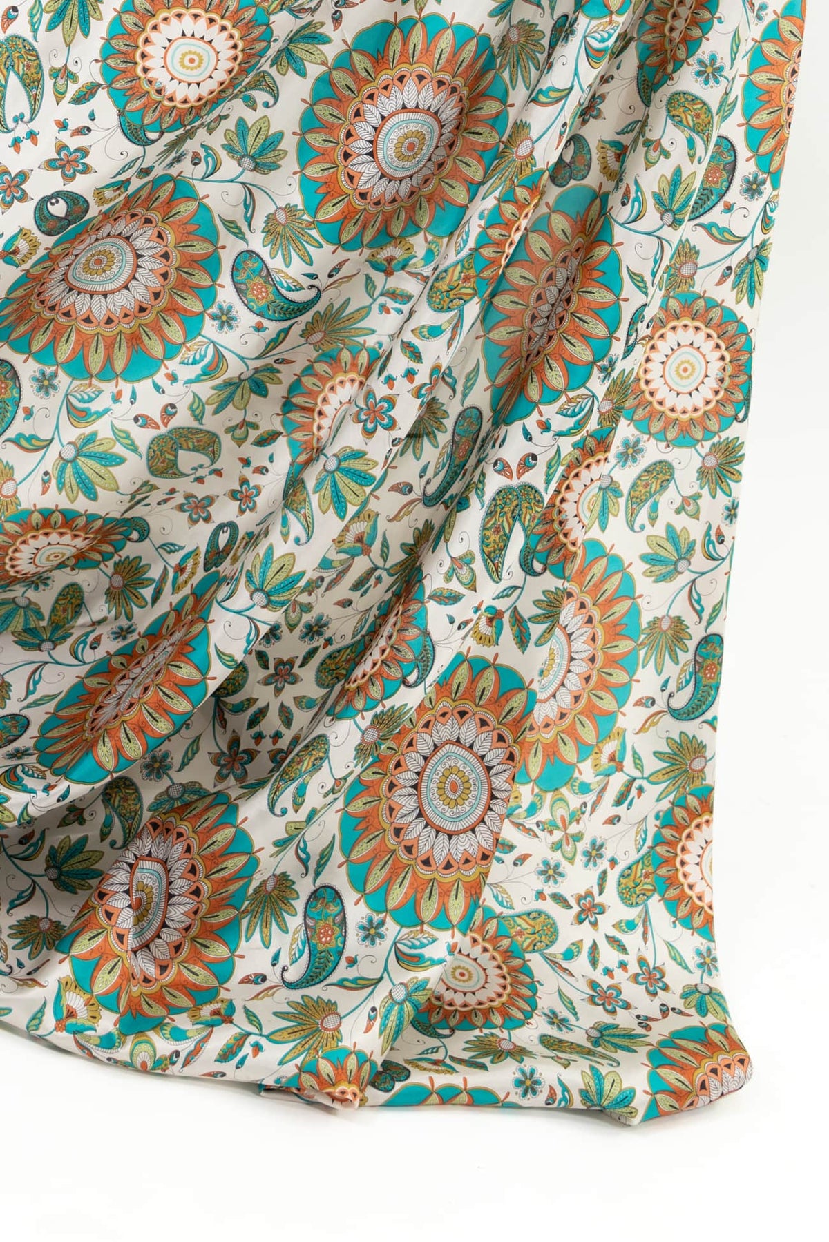 Vibrant floral and paisley print fabric in teal, orange, and cream — ideal for apparel and quilting projects.