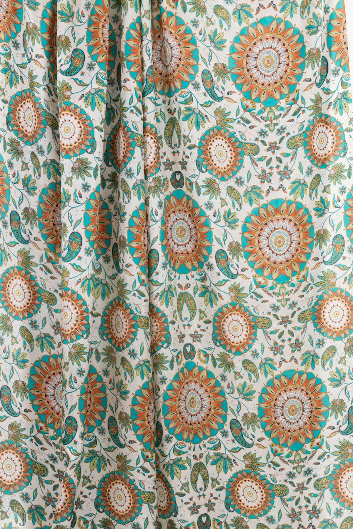 Vibrant floral and paisley print fabric in teal, orange, and cream for apparel and quilting projects
