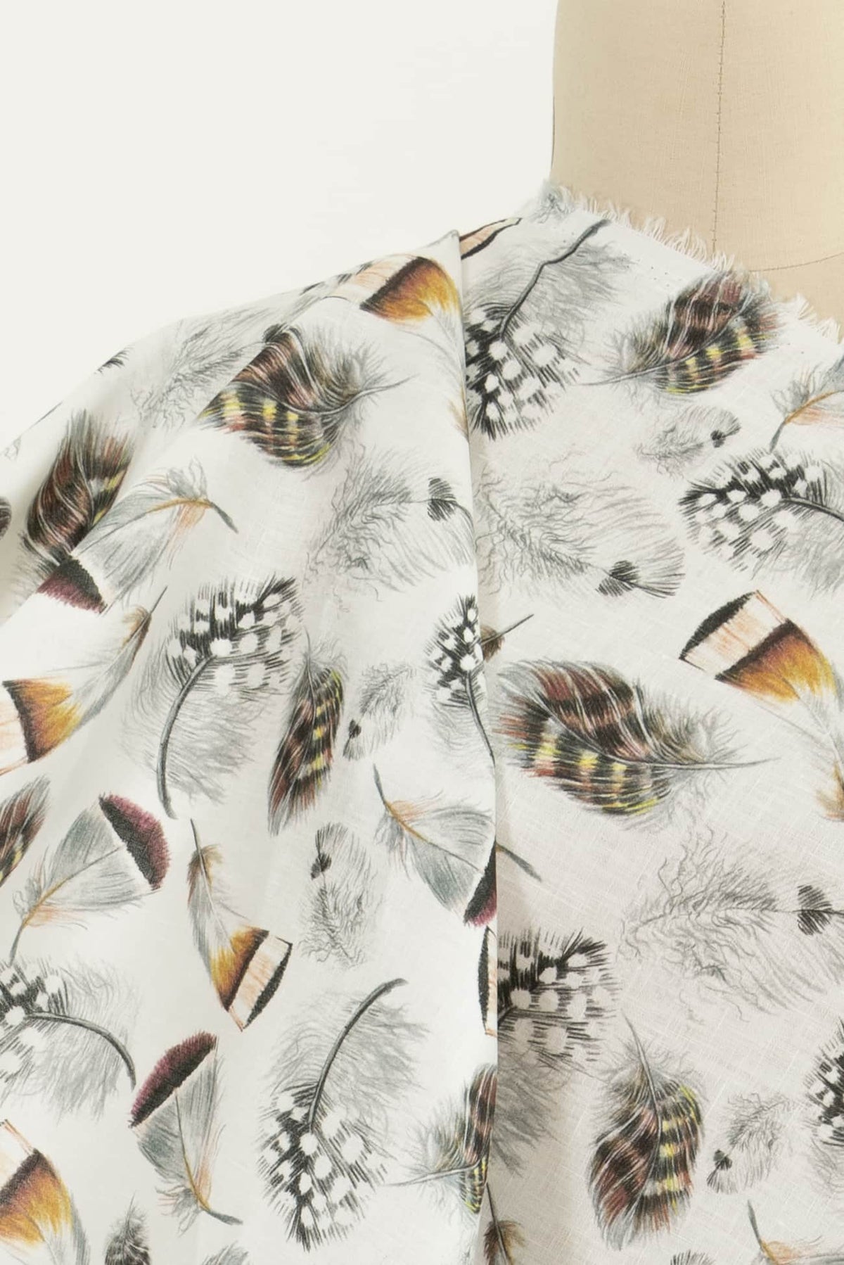 Feather print fabric in earth tones, ideal for apparel sewing and quilting projects