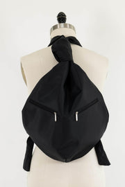 Black fabric backpack with dual zippers, styled on mannequin for sewing projects