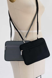 Black and gray crossbody bags with zippers displayed on a mannequin for sewing or fashion projects