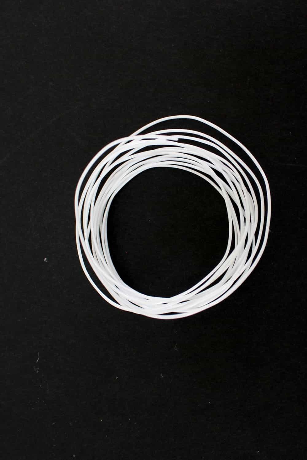 Coiled white elastic cord for sewing and crafting projects