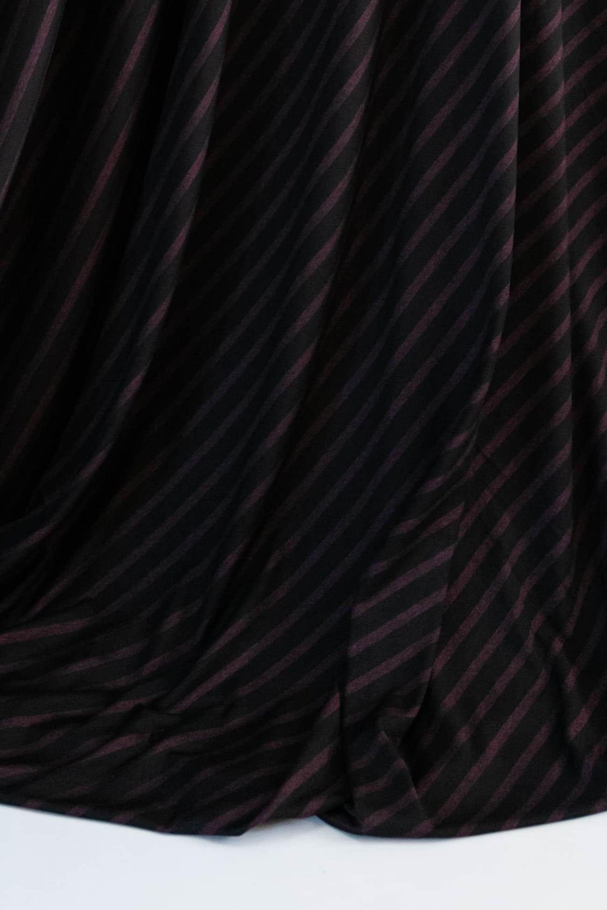 Black fabric with diagonal burgundy stripes, soft drape for apparel sewing