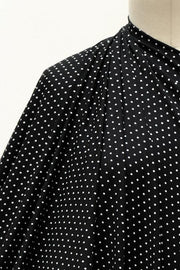 Black fabric with white polka dots, draped on mannequin for sewing projects