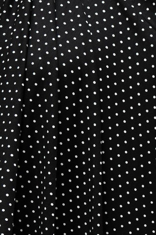 Black fabric with white polka dots, ideal for apparel sewing and fashion projects