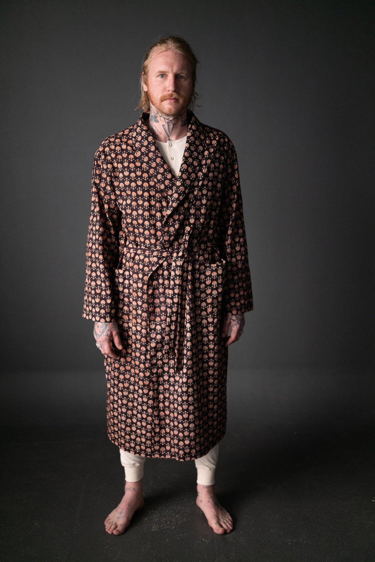 Man wearing long robe with geometric print, ideal for sewing apparel or quilting projects