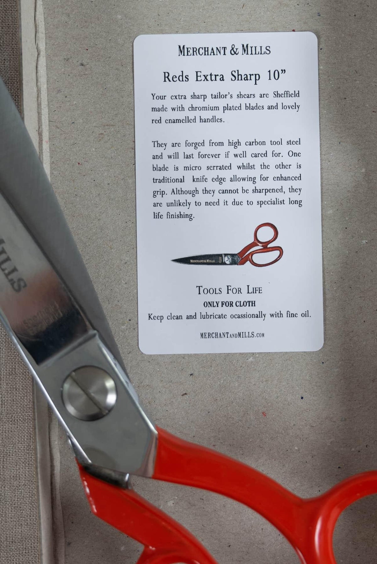 Red-handled Merchant & Mills tailor shears with info card, ideal for cutting fabric and sewing projects
