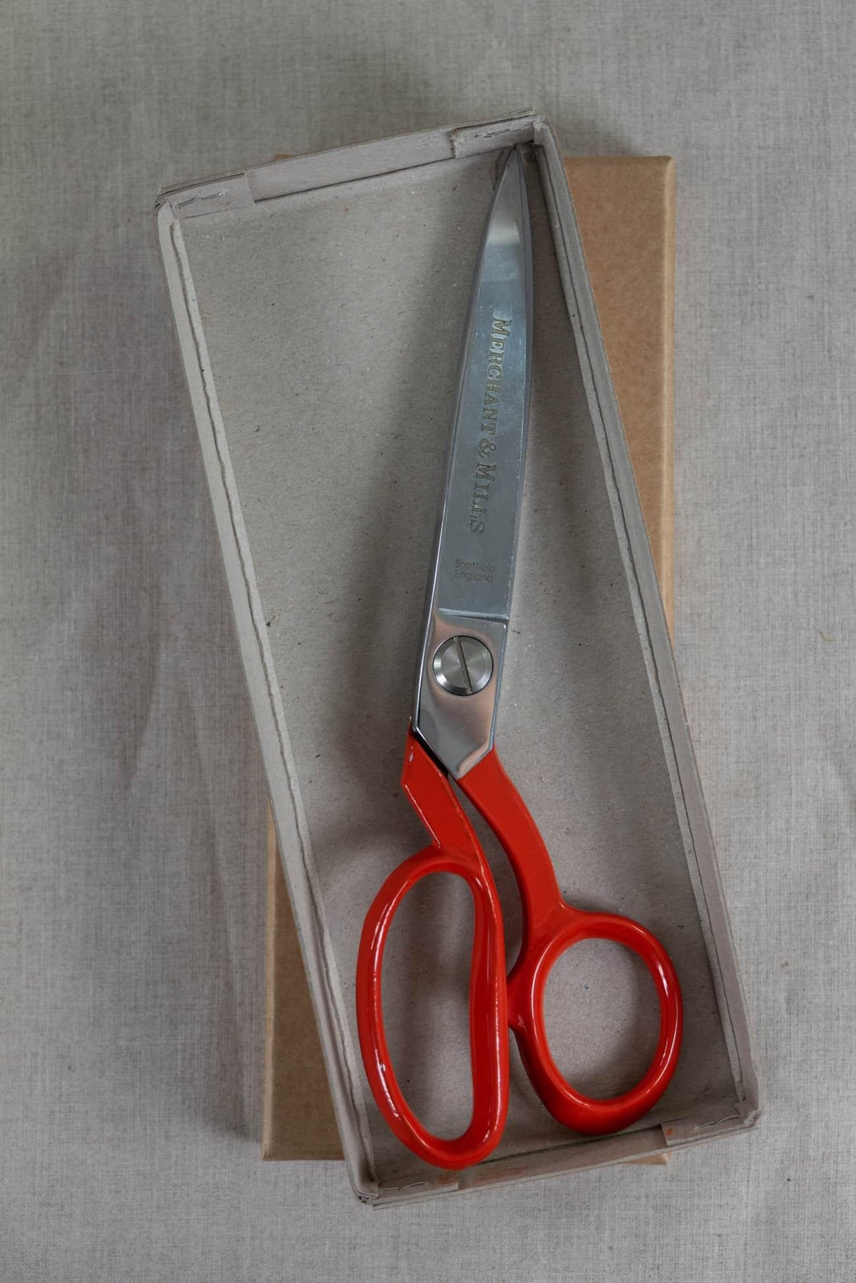 Red-handled fabric shears in box, ideal for sewing and cutting textiles