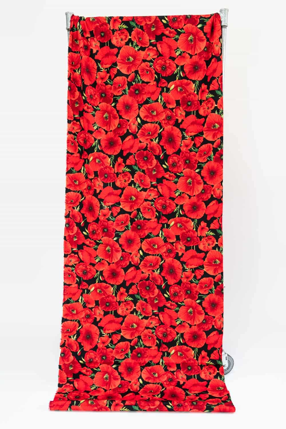 Vibrant red poppy floral print fabric on black background, ideal for apparel and quilting projects