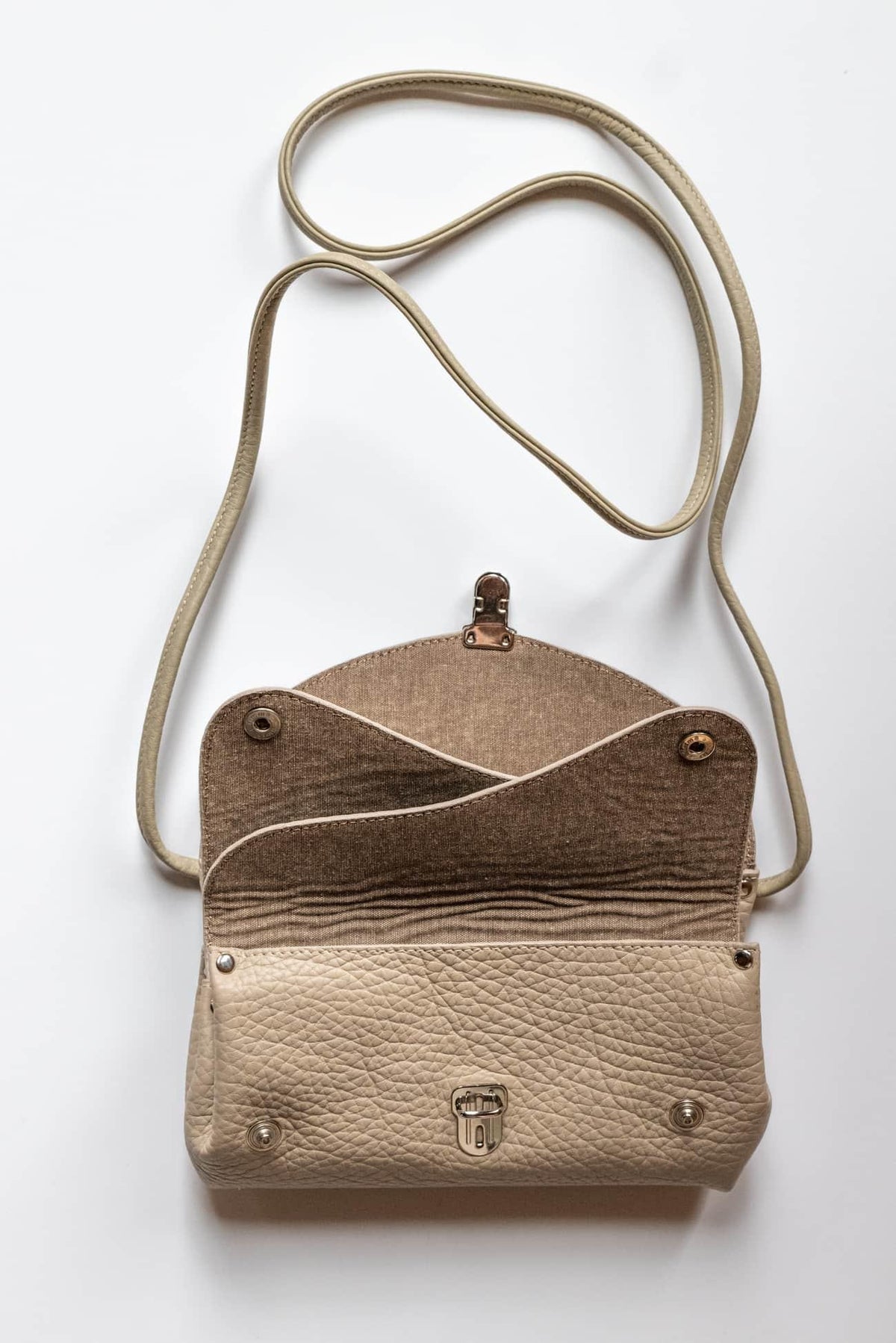 Beige textured crossbody bag with fabric flap and leather-like base, ideal for sewing projects