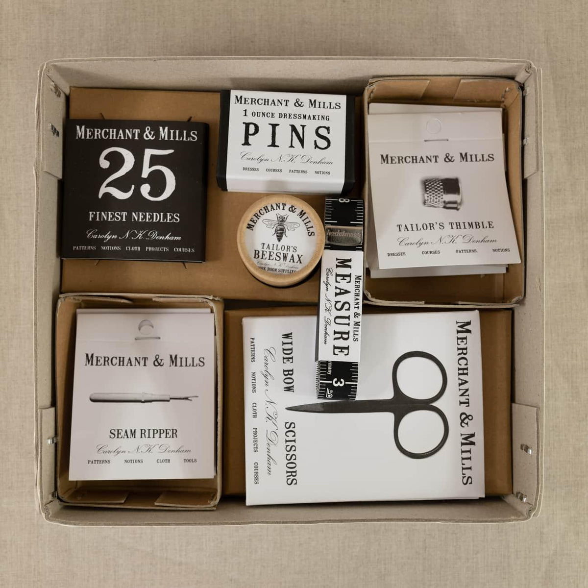 Merchant & Mills sewing kit with needles, pins, thimble, beeswax, seam ripper, scissors, and measuring tape