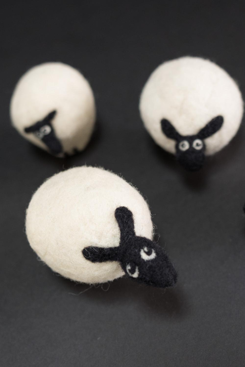 Handcrafted felt sheep ornaments with black faces, perfect for sewing and crafting projects