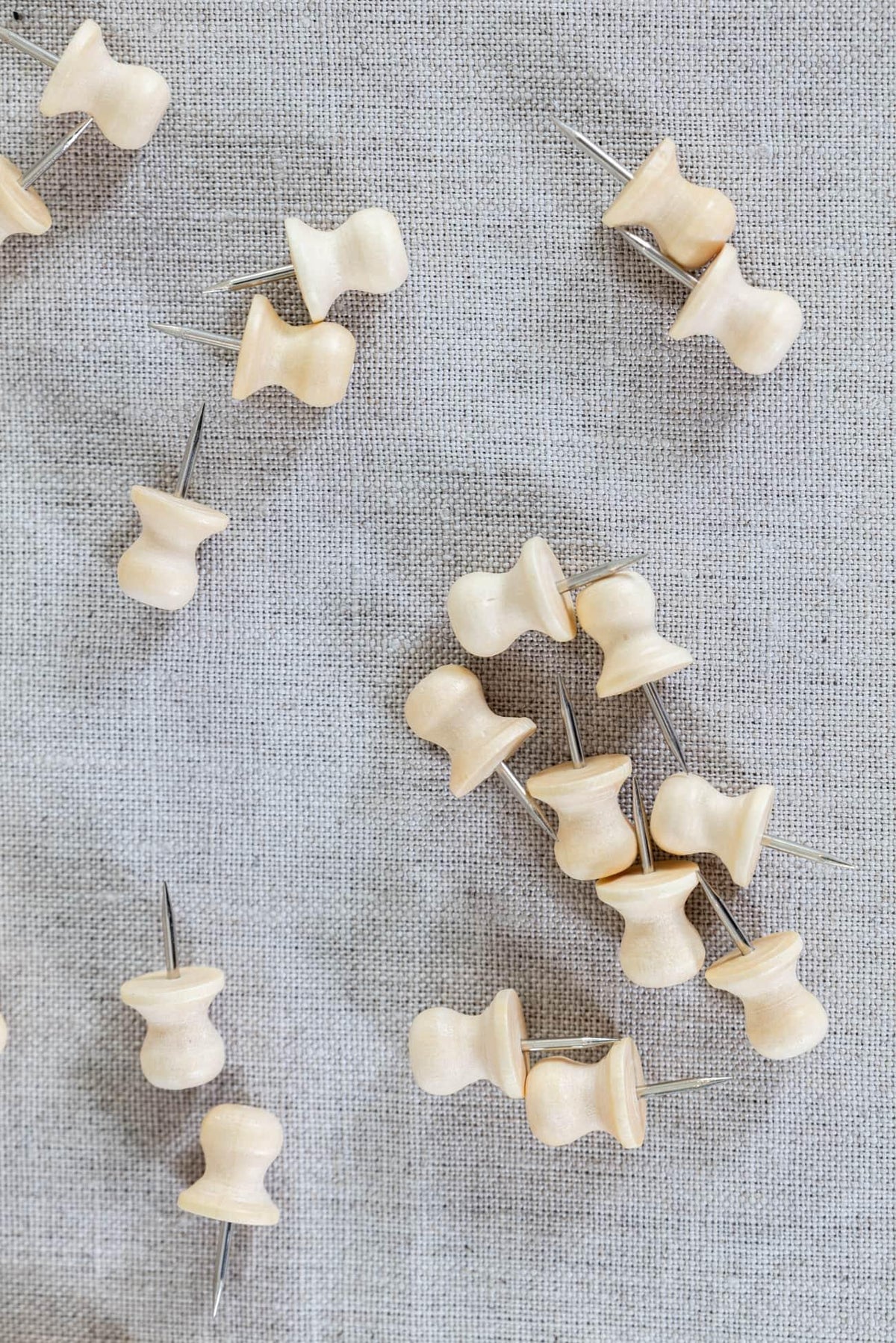 Wooden sewing pins on textured linen fabric for quilting and apparel projects
