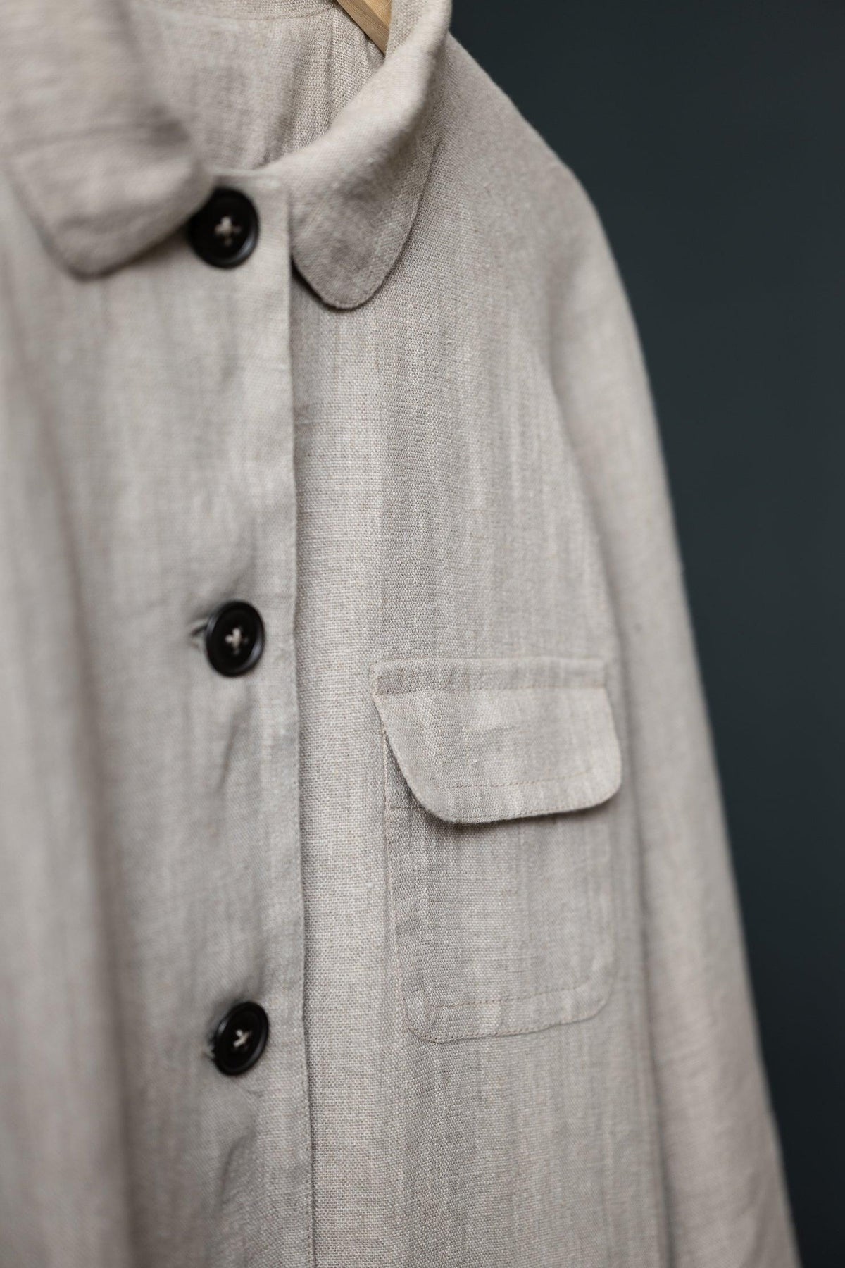 Beige linen shirt with black buttons and chest pocket, ideal for sewing apparel or quilting projects.